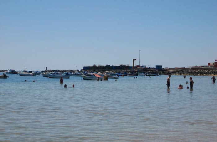 Bañistas y pequeño puerto pesquero junto a la playa de Las Teresitas